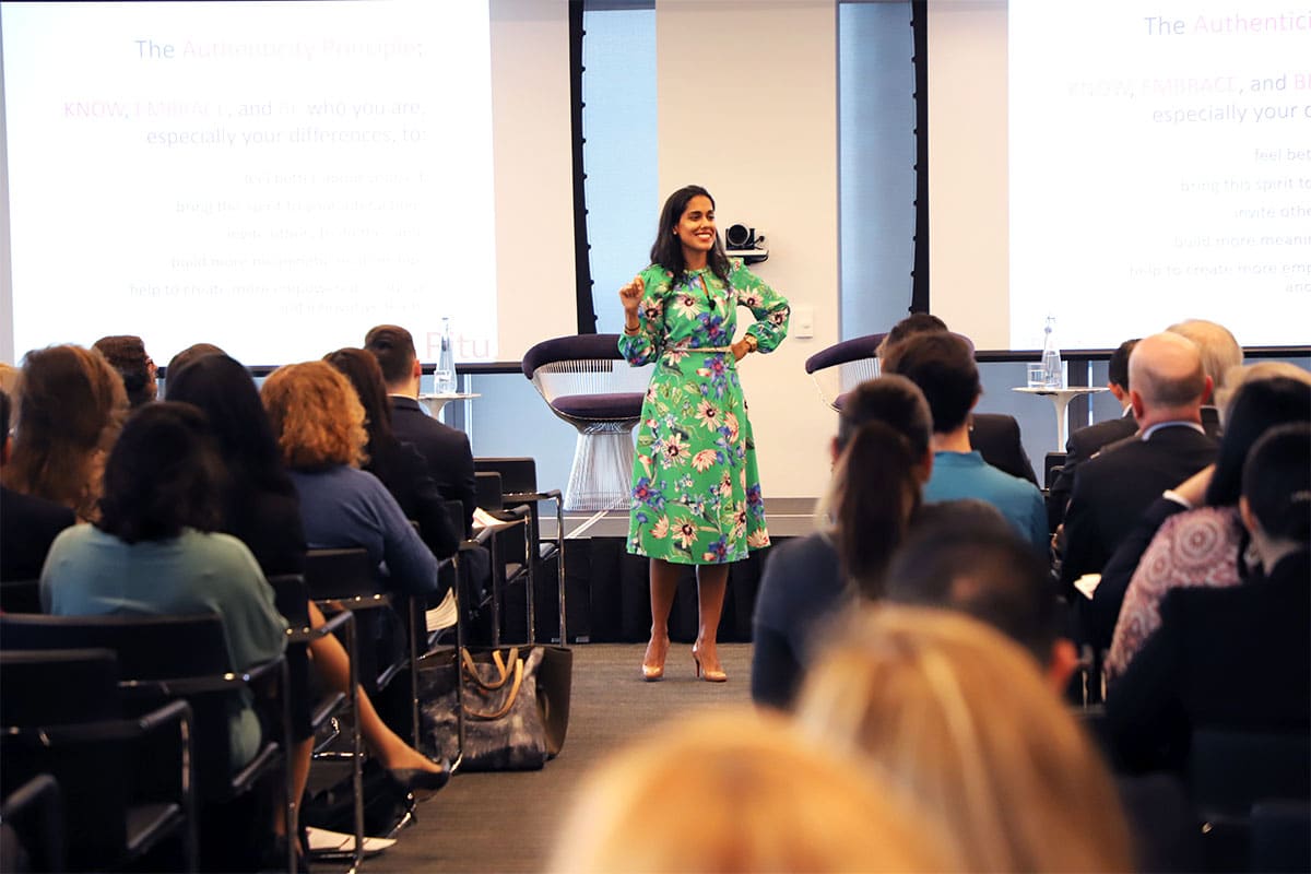 Ritu Bhasin speaking in front of a crowd of people